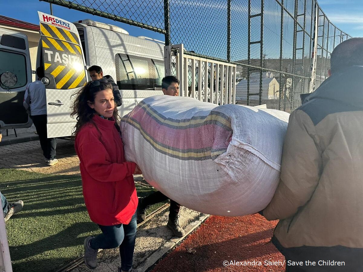 トルコの仮設キャンプで配布する救援物資（マットレスと毛布）を運ぶスタッフ​